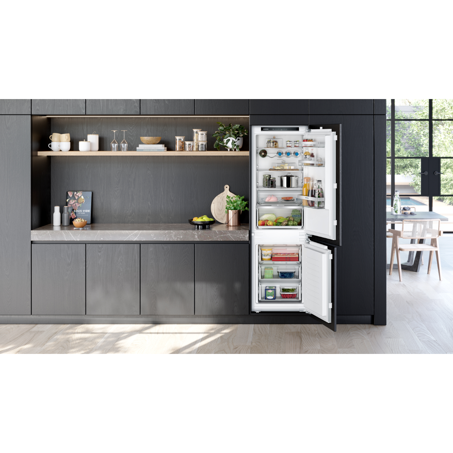 Open refrigerator with shelves full of food. Gray kitchen cabinets in the background.