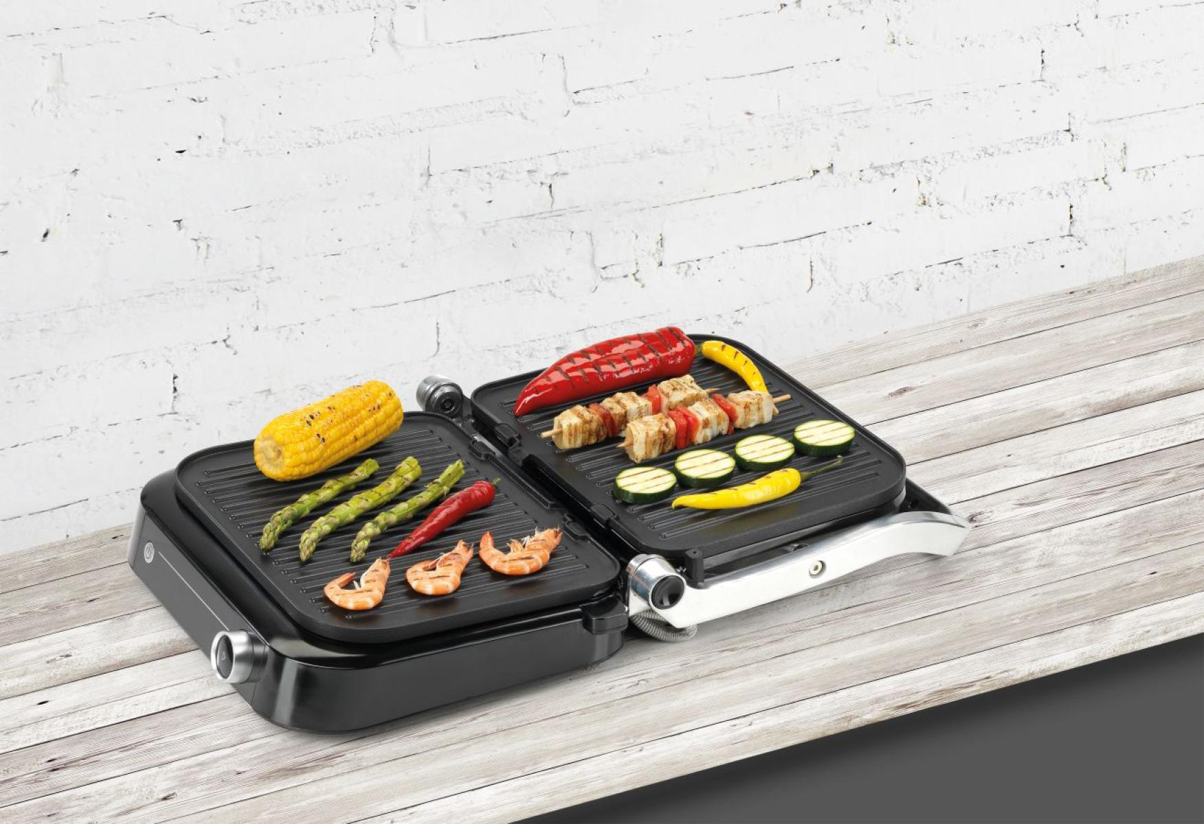 Egy grill különböző típusú grillezett ételekkel. Zöldségek és garnélarák látható.