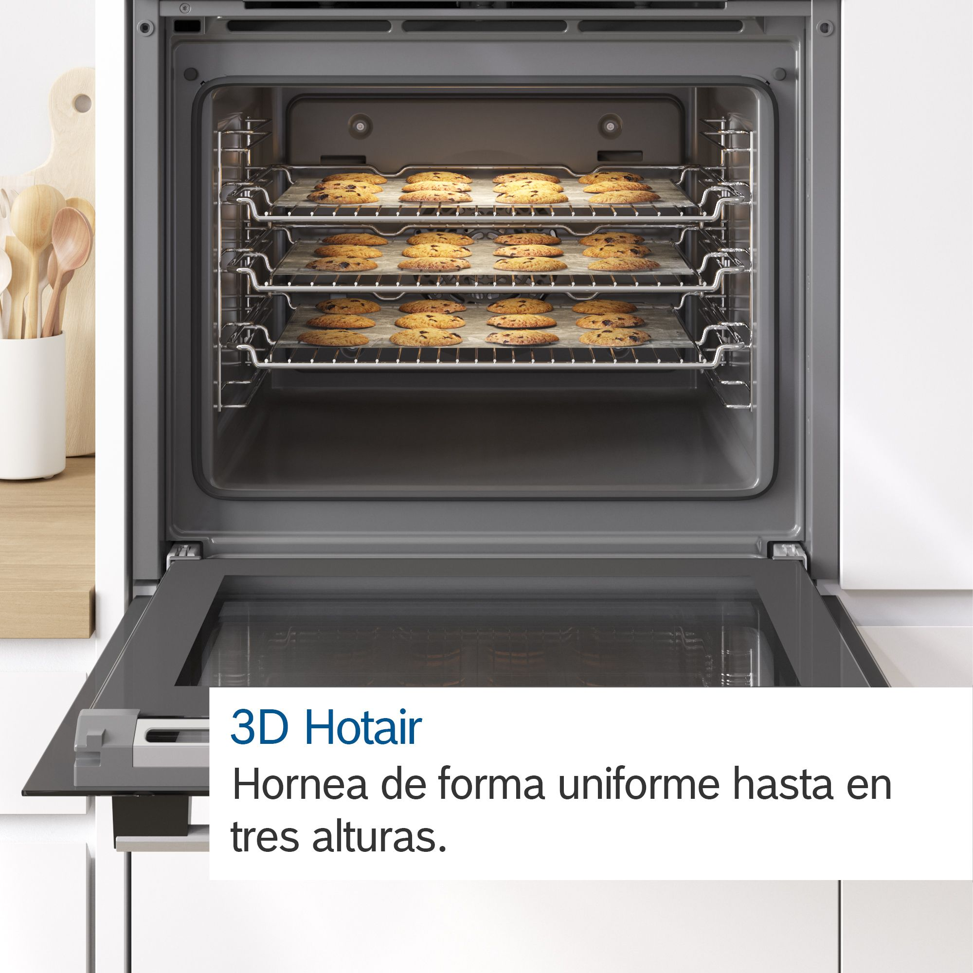 Interior de horno con tres bandejas de galletas horneándose, puerta abierta.