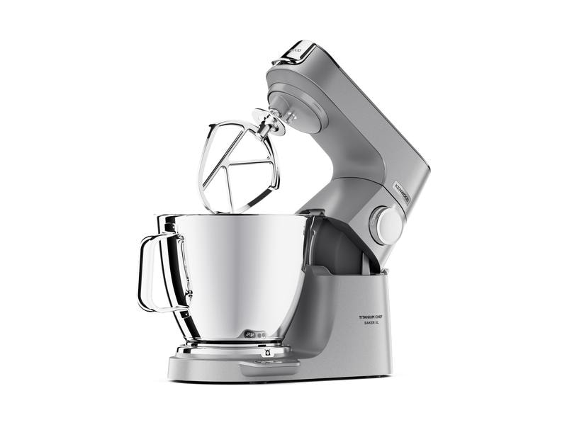 Robot pâtissier argent et gris avec bol et accessoires, isolé sur fond blanc.