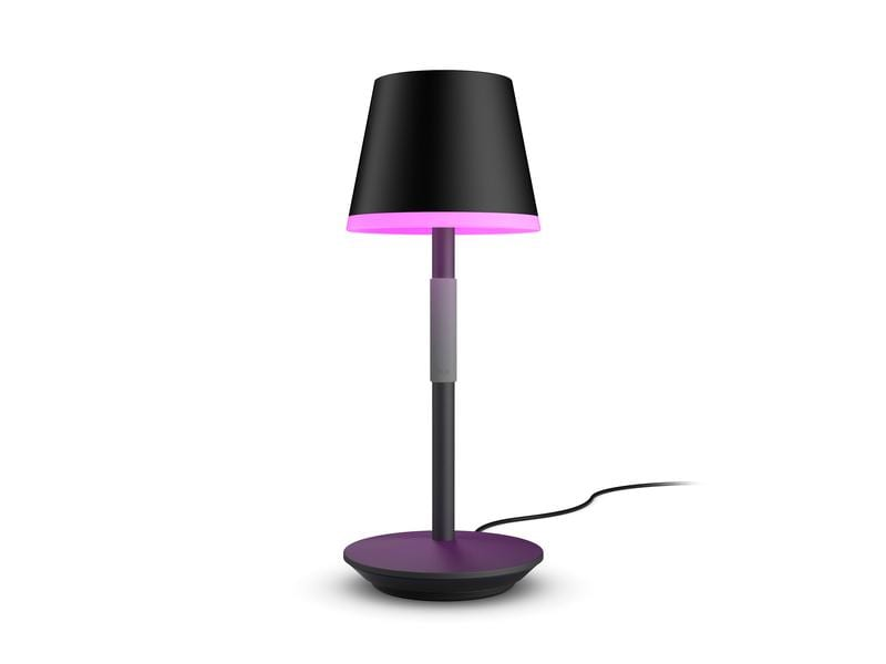 Eine Lampe mit schwarzem Schirm, silbernem Stiel und lila Sockel. Sie ist eingesteckt.