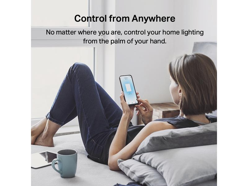 Frau liegt auf dem Boden und bedient eine Smart-Home-App auf ihrem Handy.