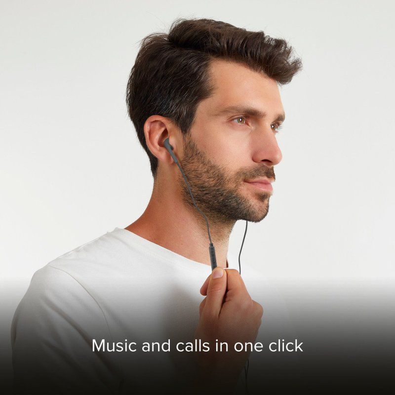 Mężczyzna z słuchawkami, trzymający kabel, białe tło.