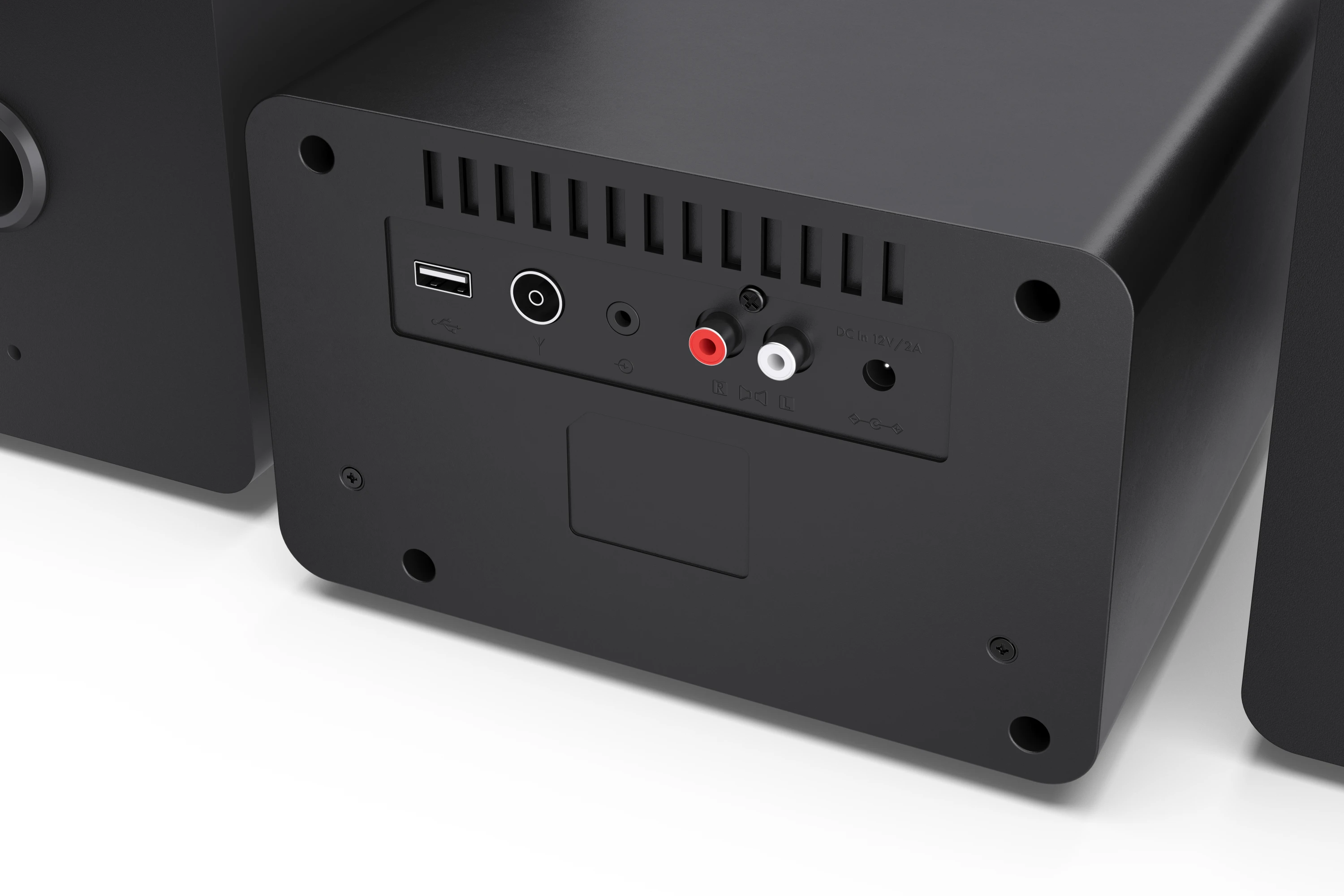 Fekete hangszóró hátlapja különböző portokkal, beleértve az USB-t, a hangbemeneteket és a tápellátást.