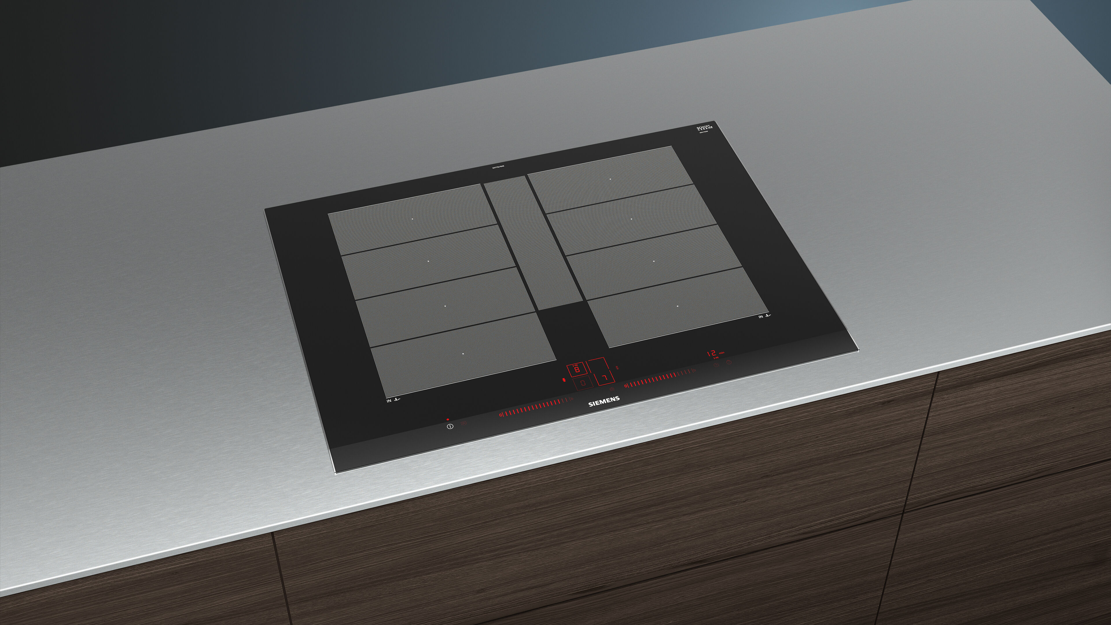 Placa de inducción negra empotrada en encimera plateada, con controles rojos iluminados y dos zonas de cocción.
