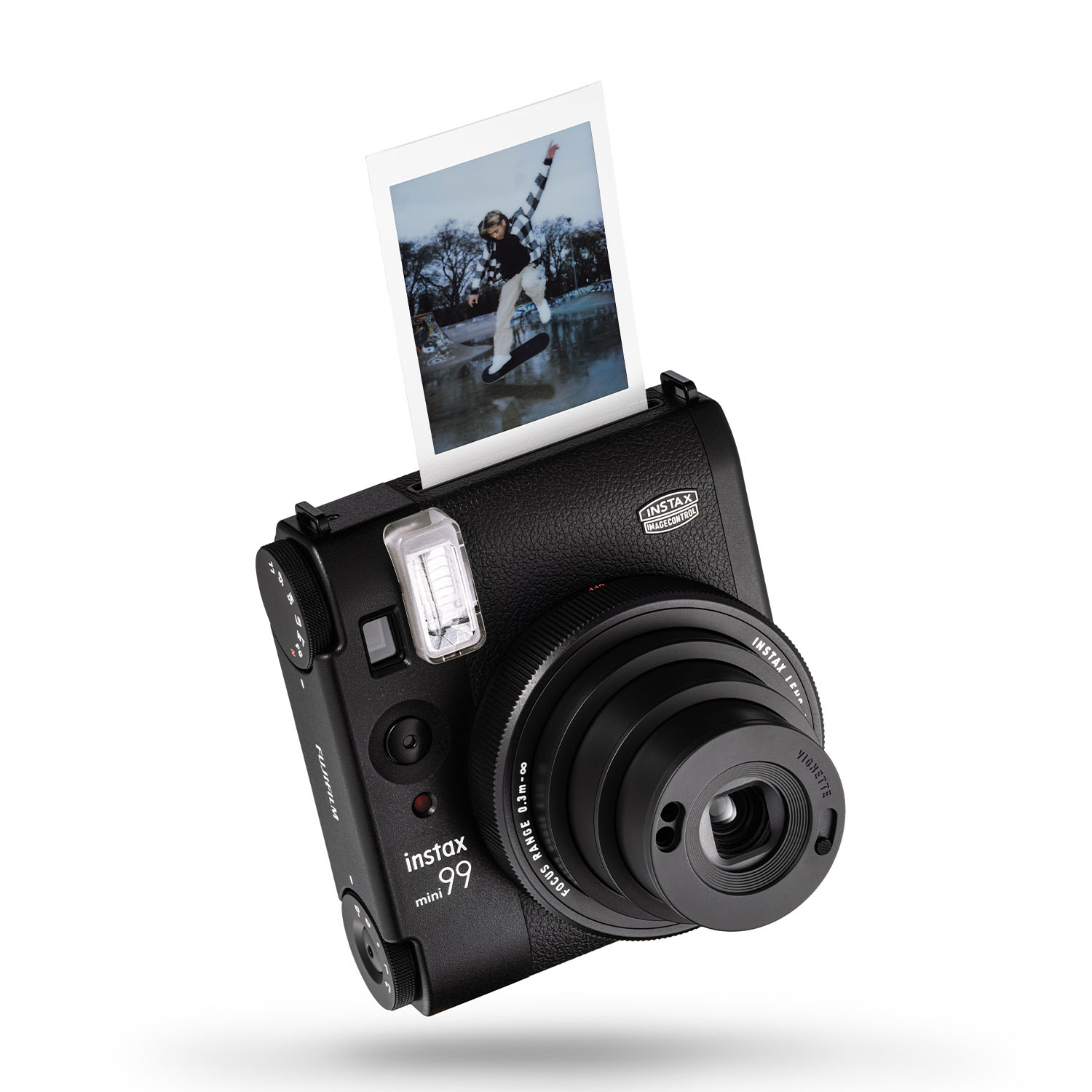Fotocamera Instax nera con foto espulsa. Persona sulla foto che fa skateboard.