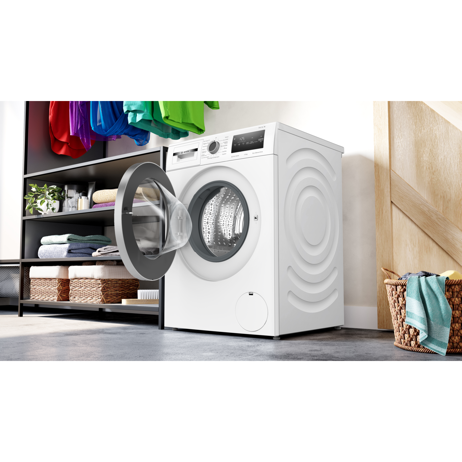 Witte wasmachine met een open deur, wasgoed en een mand.