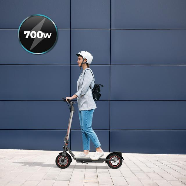 Kobieta na skuterze. Niebieska ściana w tle z logo 700w.