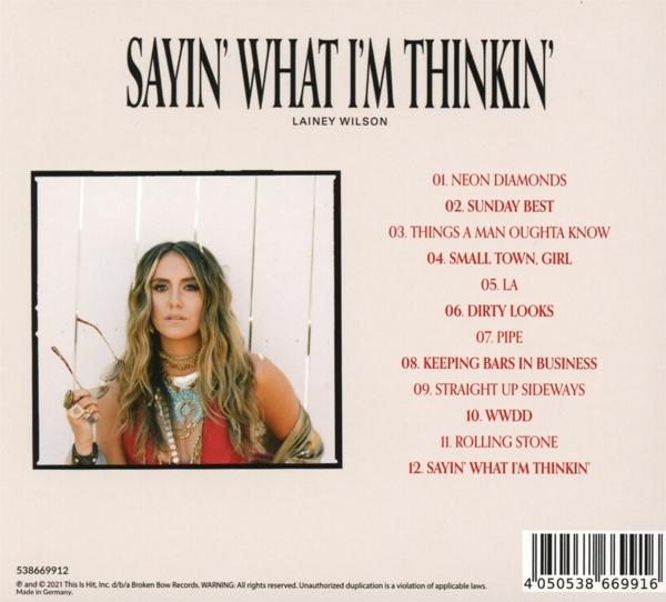 Albumcover mit einer Frau, die eine Brille hält, umgeben von Text und einer Titelliste.