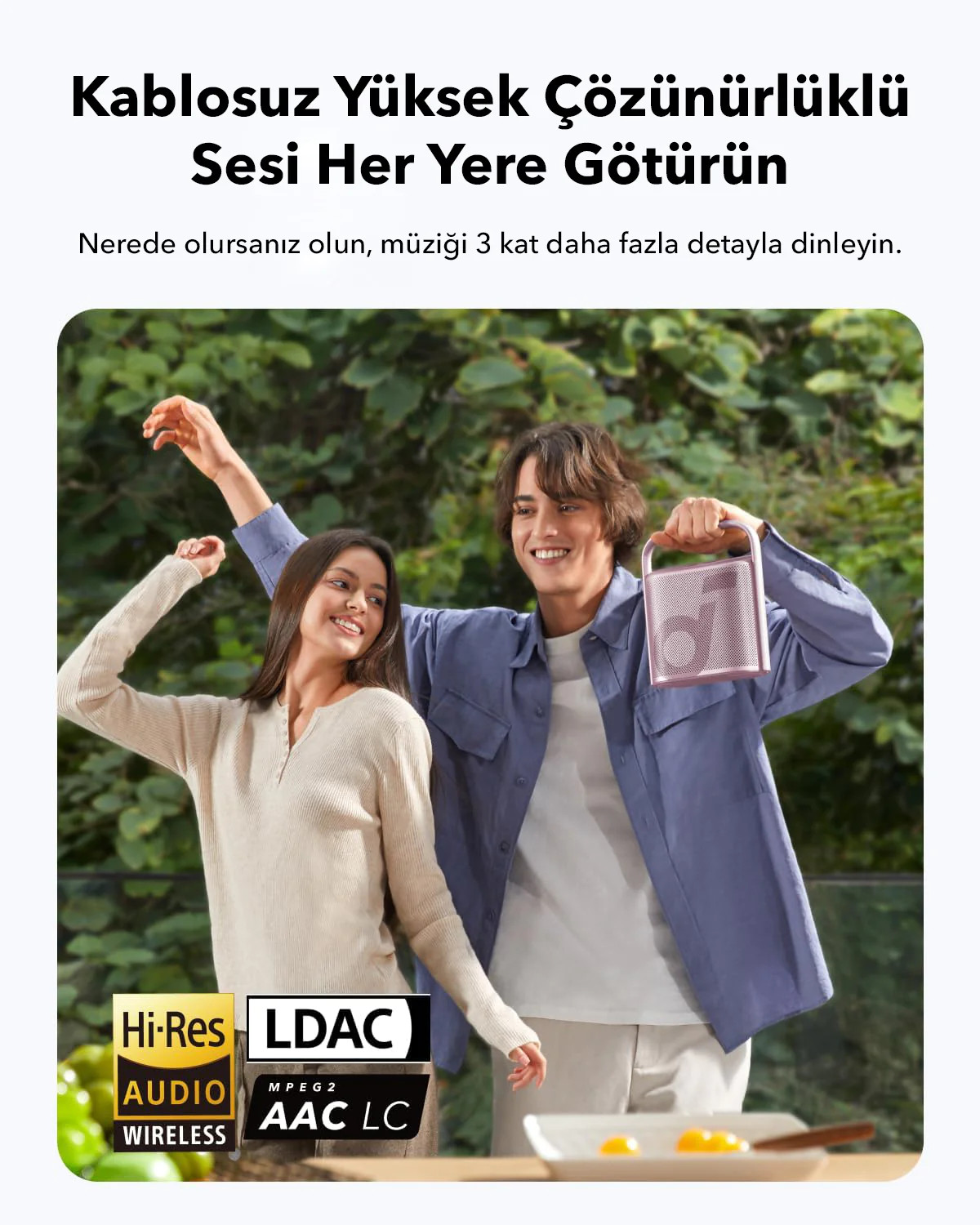 İki kişi pembe bir taşınabilir hoparlör tutuyor, müzik ve kablosuz ses logolarıyla.