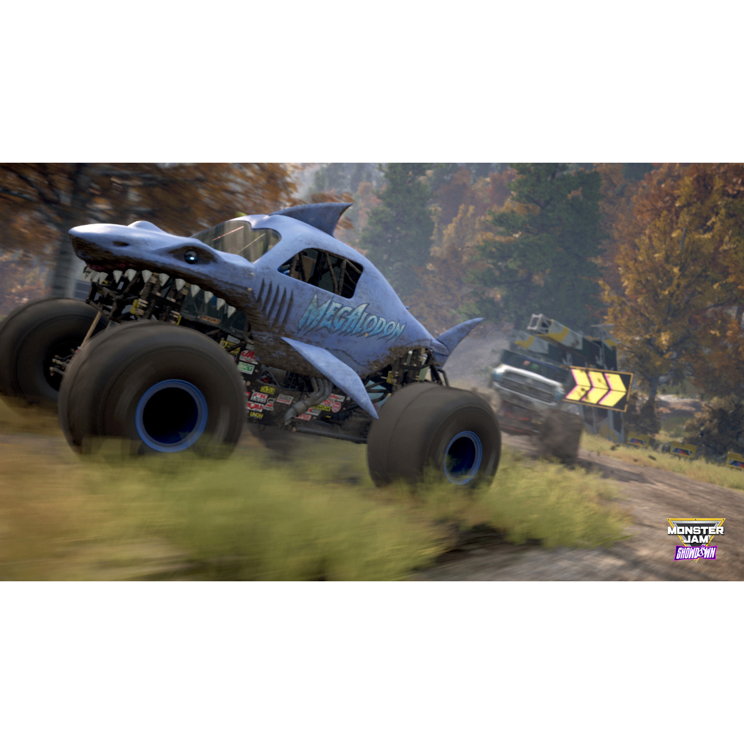 Monster truck racen op een zandbaan. Eén truck is blauw, met een haaienthema. De andere is geel.