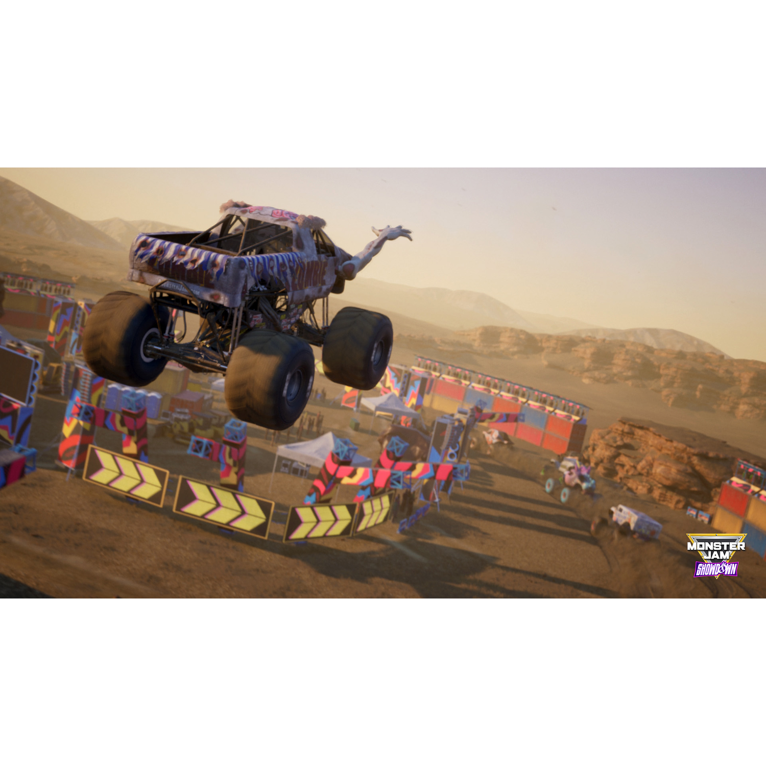 Een monstertruck springt over obstakels in een woestijnrace. De lucht is helder.