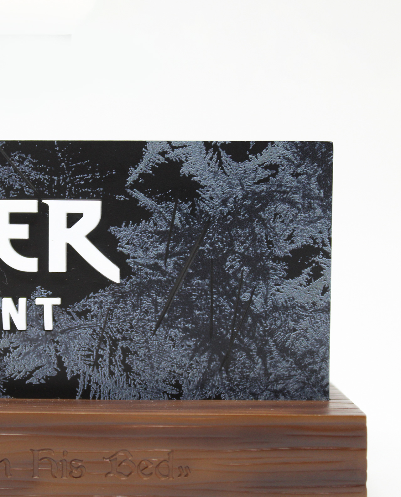 Schwarzes Schild mit weißem Text auf Holzsockel. Teil eines Filmsets.