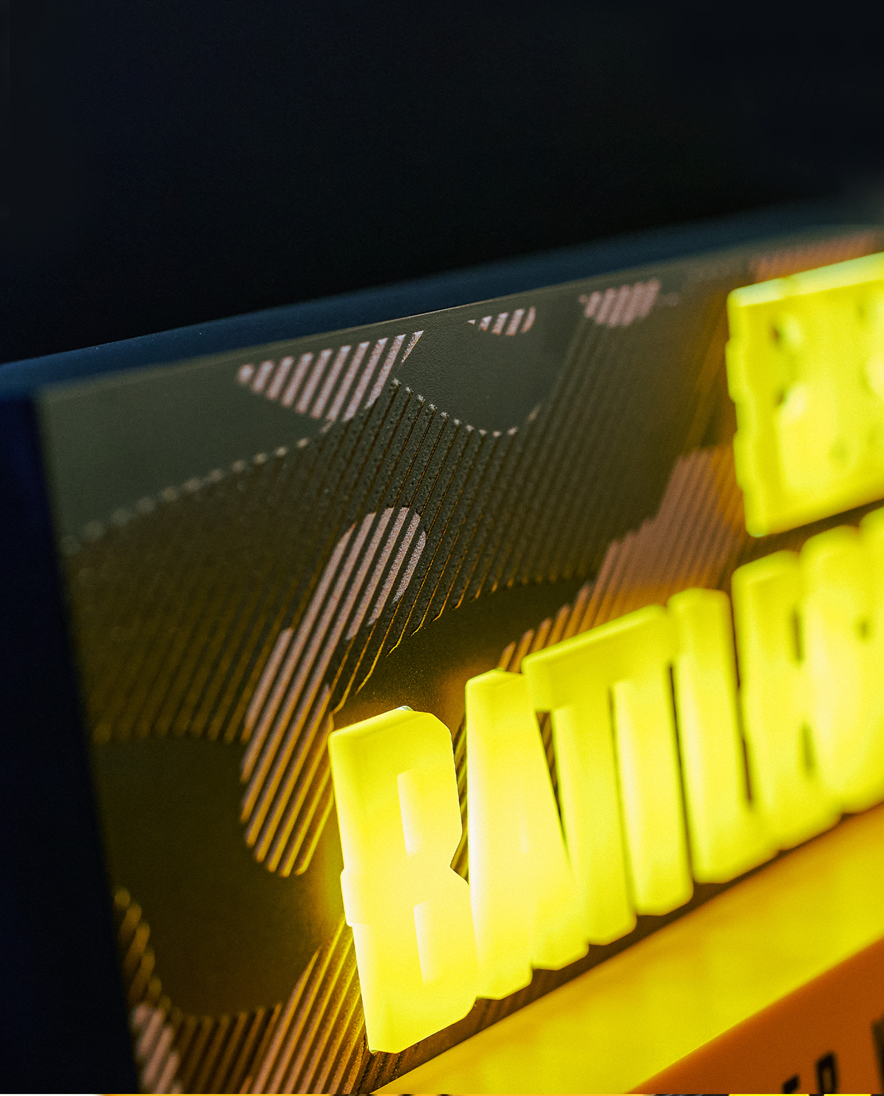 Nahaufnahme eines beleuchteten Batman-Schildes mit gelben Buchstaben und dunklem Hintergrund.