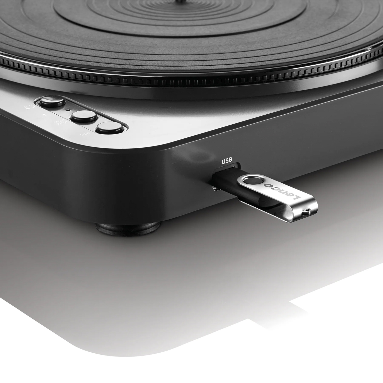 Un giradischi nero con una chiavetta USB inserita. Lo sfondo è bianco.