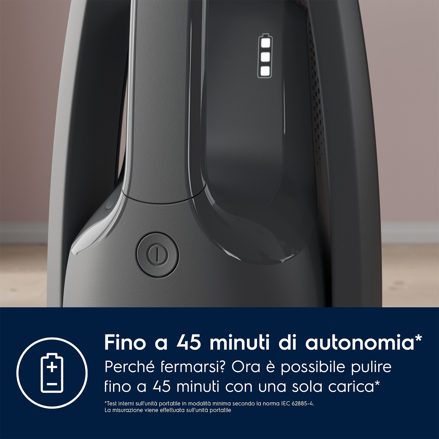 Primo piano di un aspirapolvere grigio scuro con indicatore della batteria. Testo in italiano.