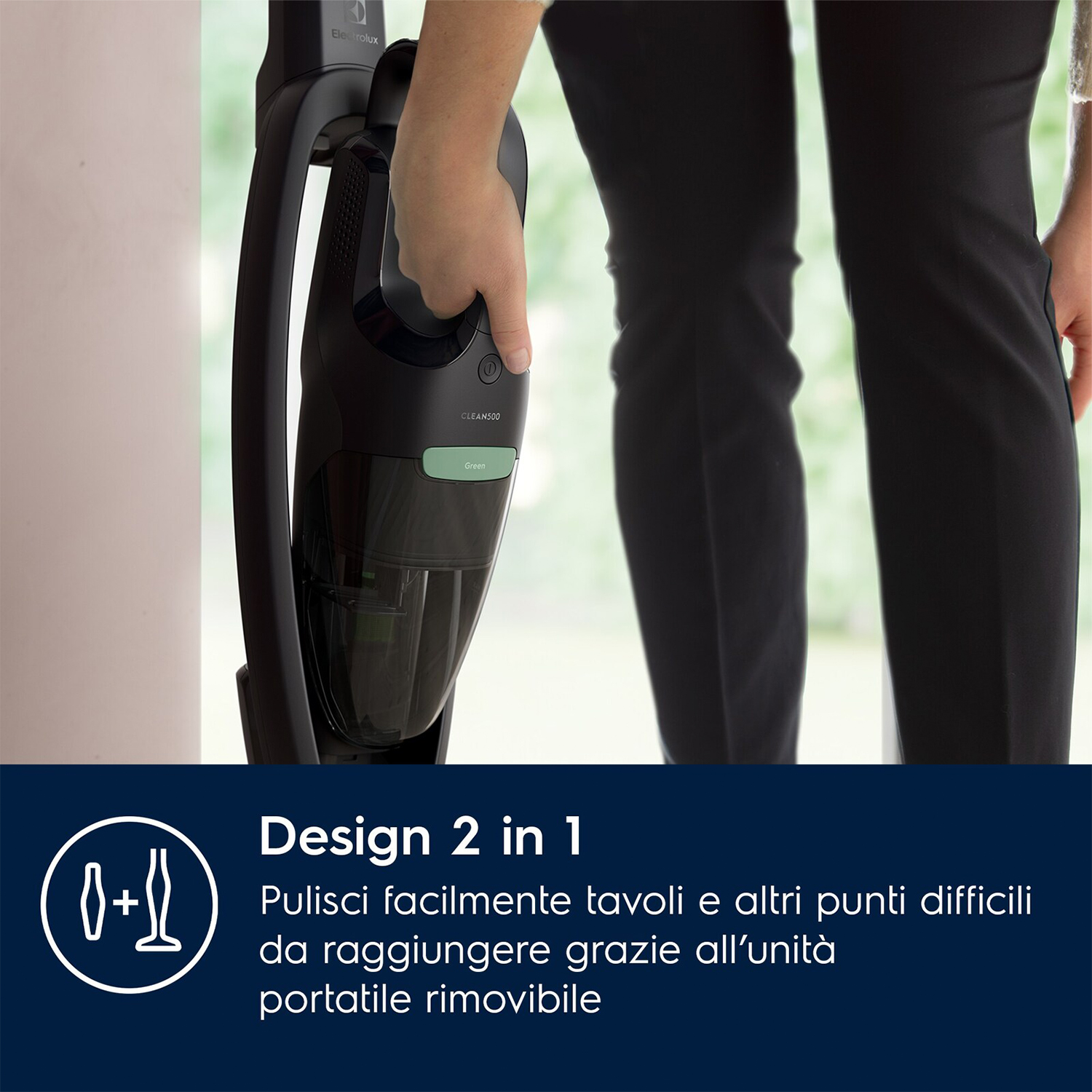 Mano di una persona che tiene un aspirapolvere senza fili. L'aspirapolvere ha un contenitore trasparente.