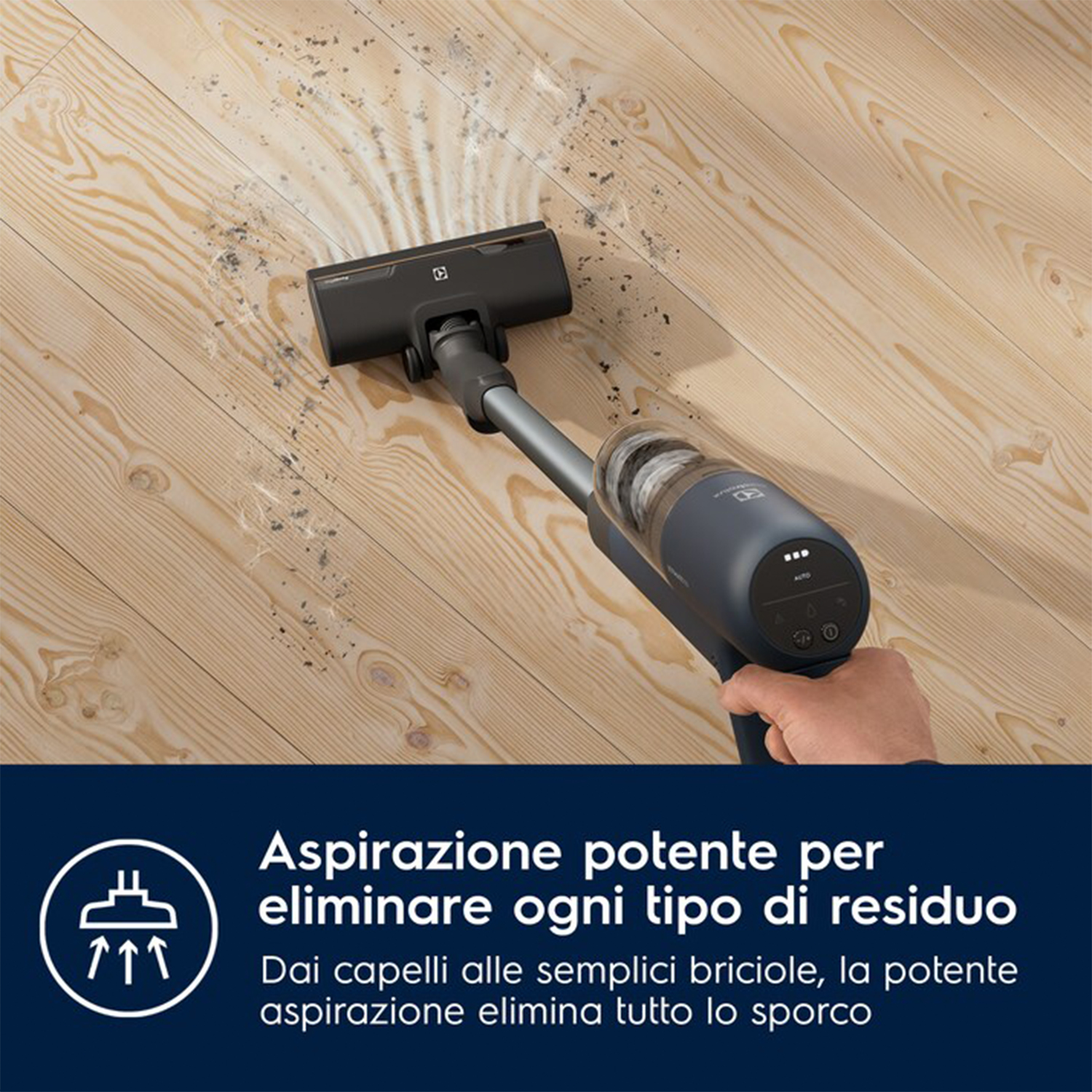 Una persona che pulisce un pavimento in legno con un aspirapolvere portatile.