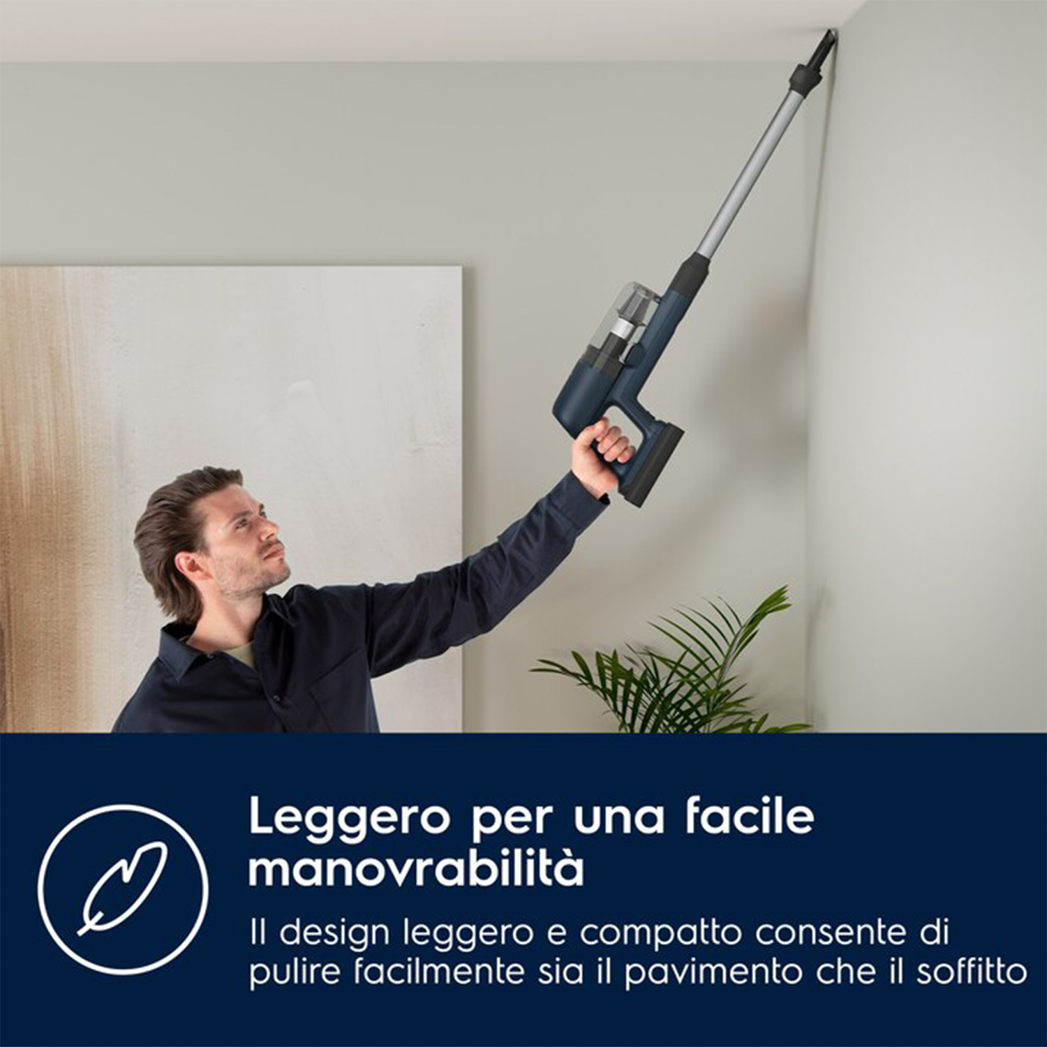 Uomo che usa un aspirapolvere senza fili per pulire il soffitto. Testo: Design leggero.