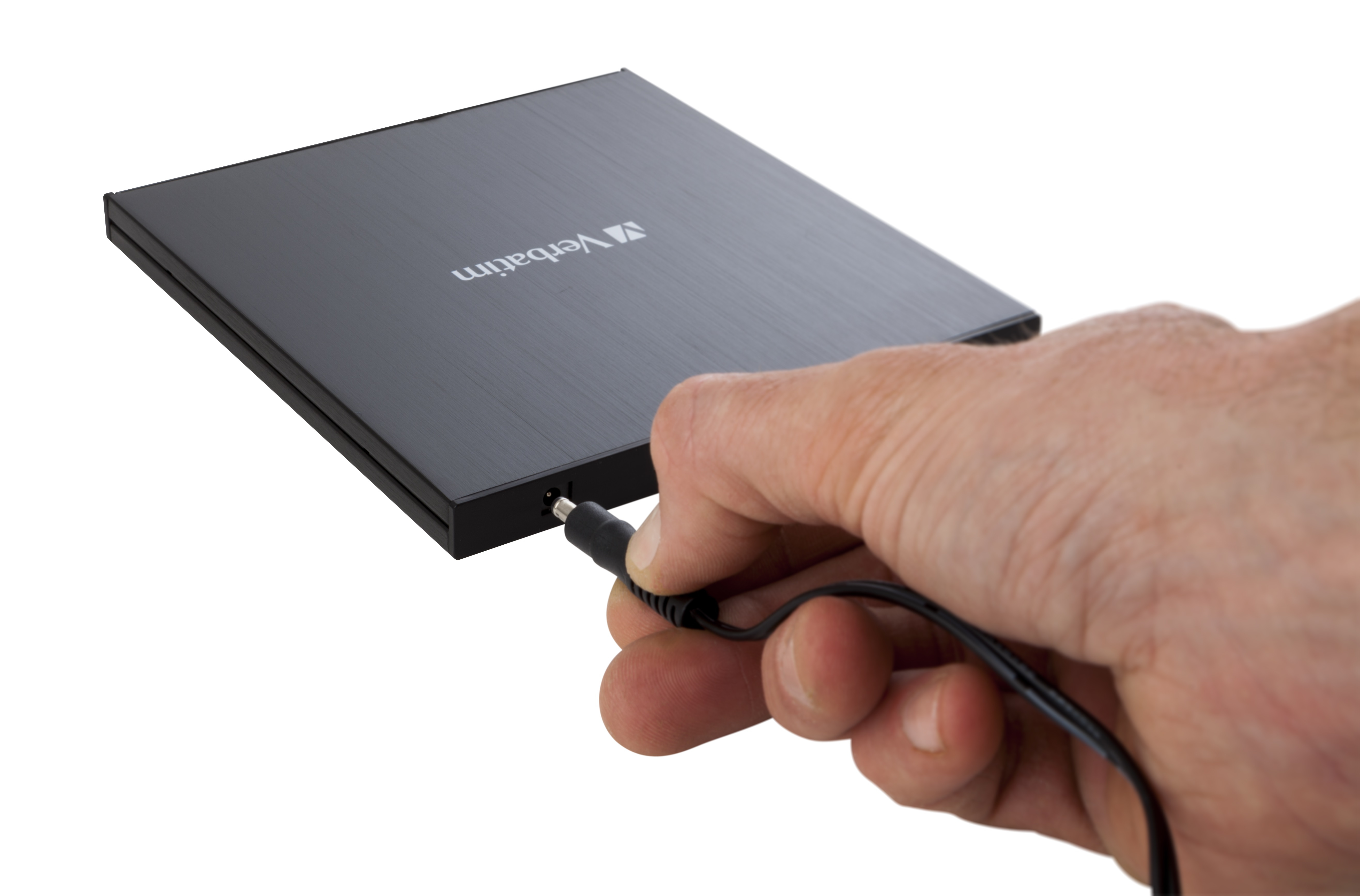 Eine Hand, die einen schwarzen Netzadapter in eine schwarze portable Festplatte steckt.