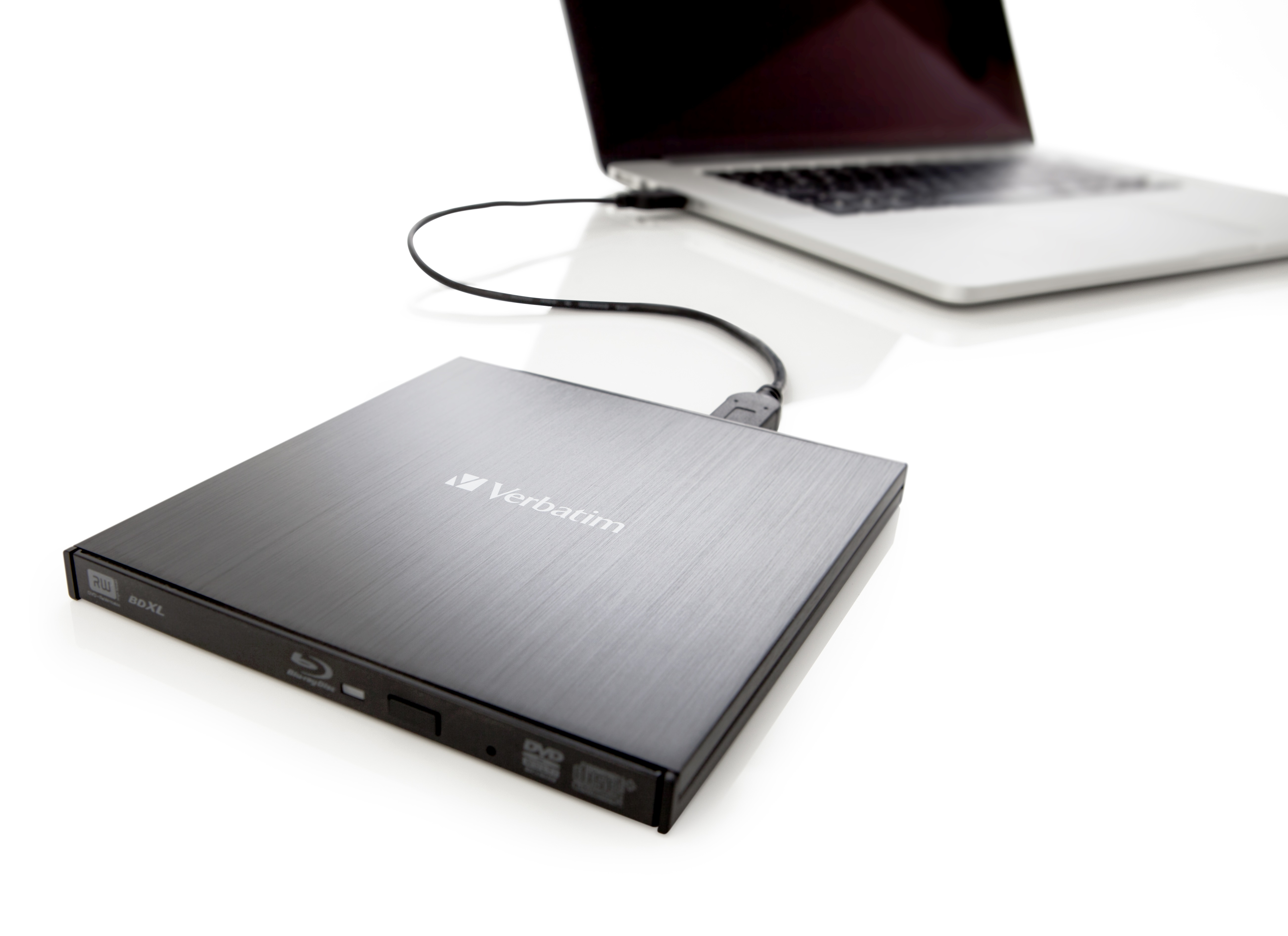 Schwarzes DVD-Laufwerk, das über ein schwarzes Kabel mit einem silbernen Laptop verbunden ist.