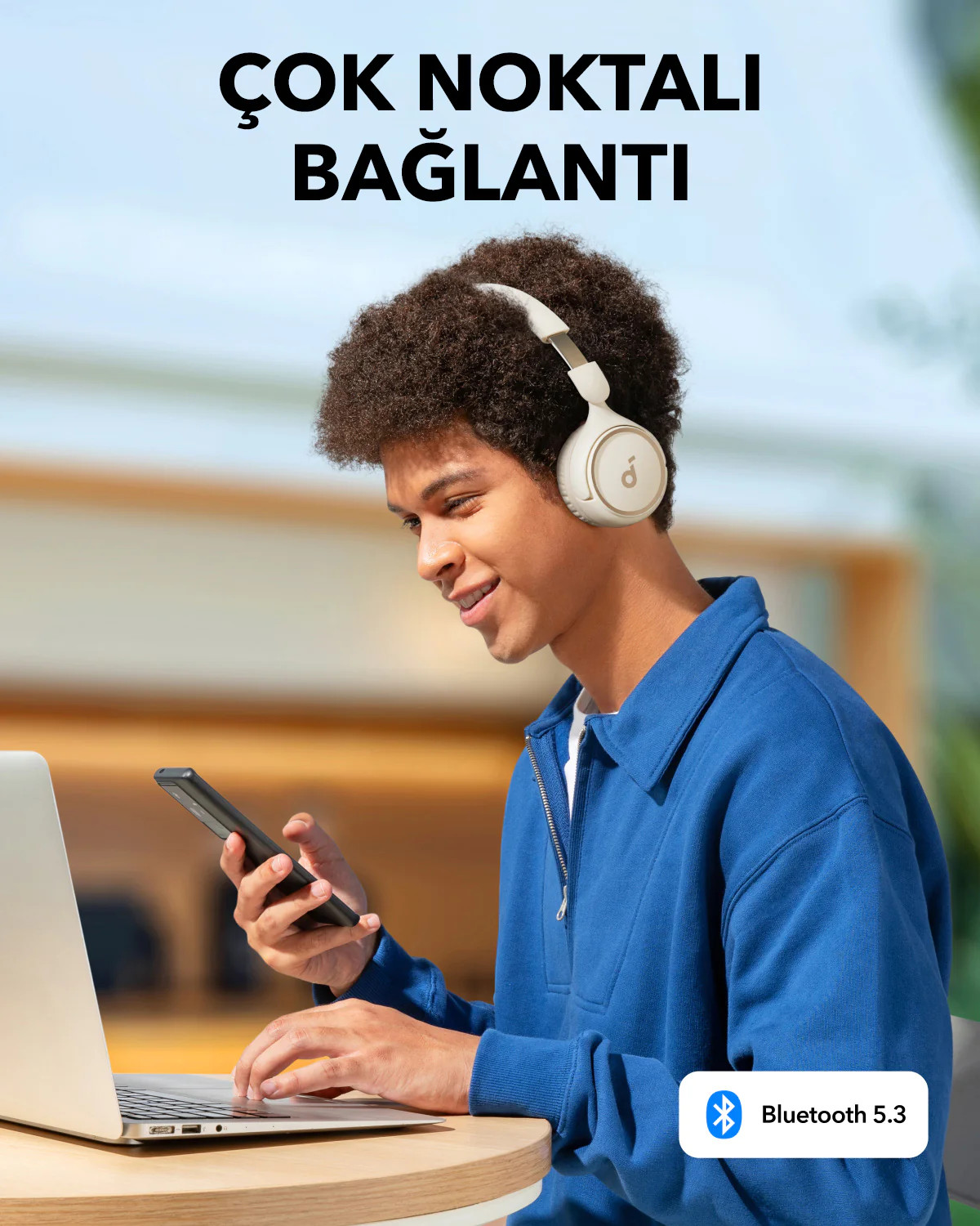 Beyaz kulaklık takan ve bir telefona bakan bir kişi.