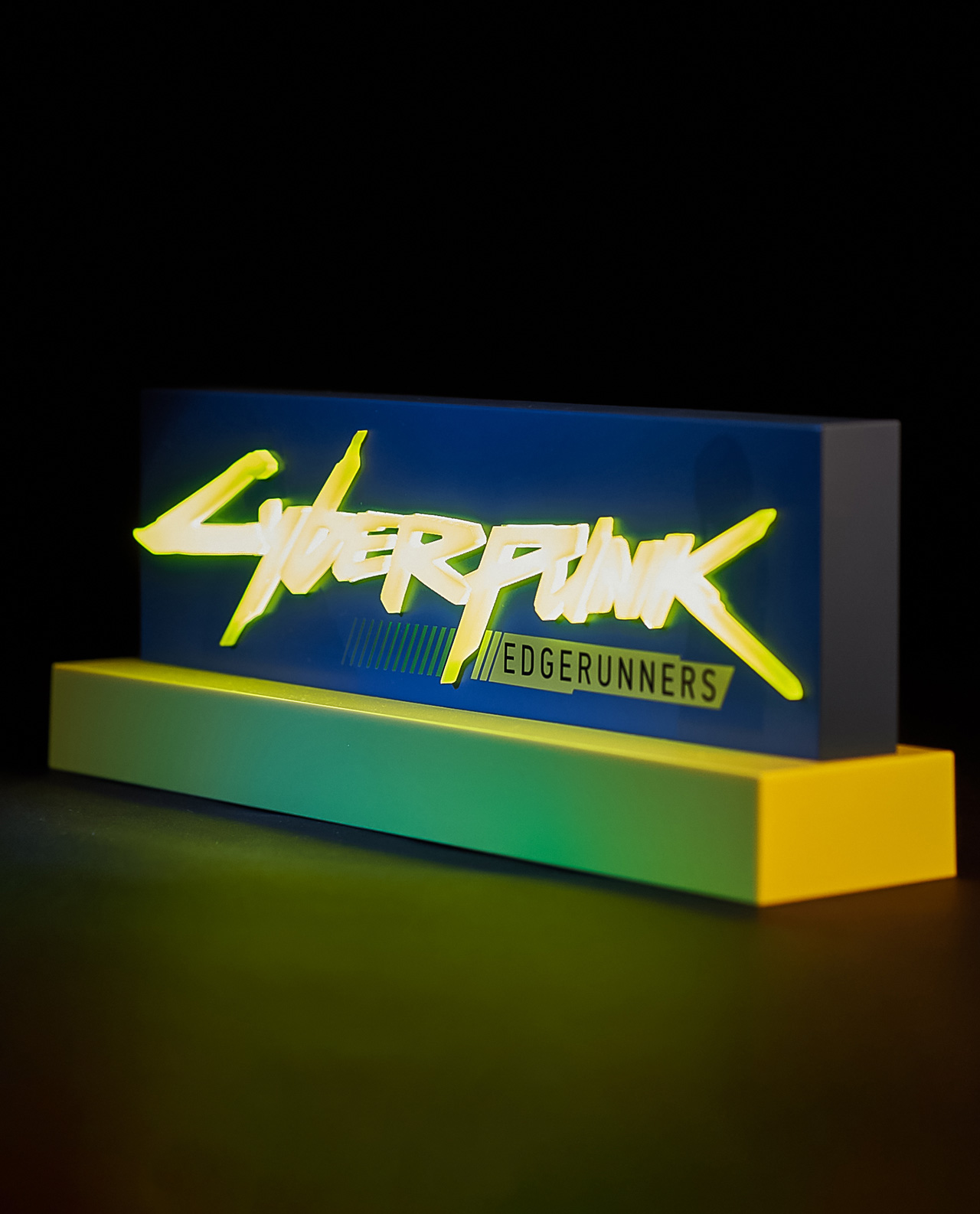 Cyberpunk Edgerunners Neon-Schild auf gelber Basis, mit blauem Hintergrund und schwarzem Hintergrund.