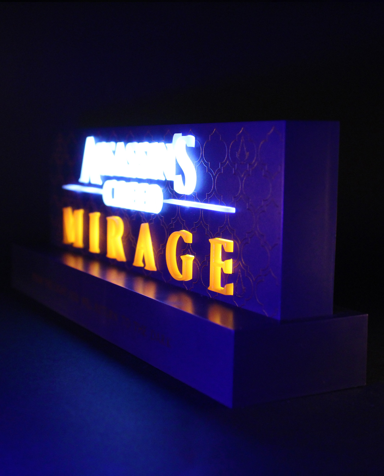 Ein Neonschild für Assassin's Creed Mirage mit blauen und gelben Lichtern auf dunklem Hintergrund.