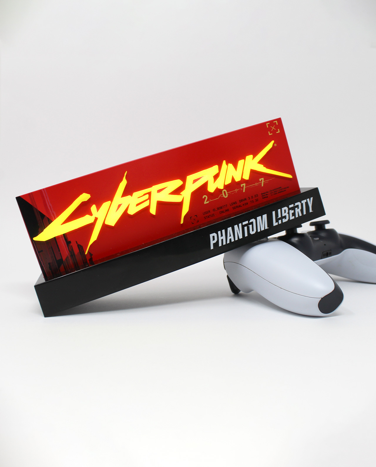 Cyberpunk 2077: Phantom Liberty Box auf einer Präsentation, mit zwei Spielecontrollern.