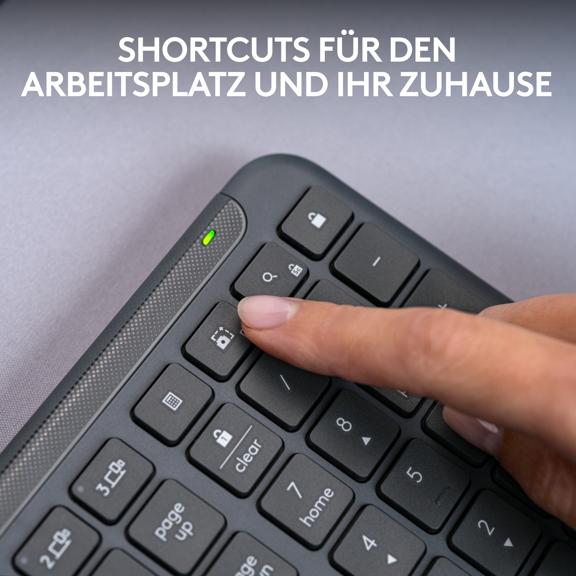 Ein Finger drückt eine Taste auf einer dunklen Tastatur, mit Textüberlagerung, vor grauem Hintergrund.