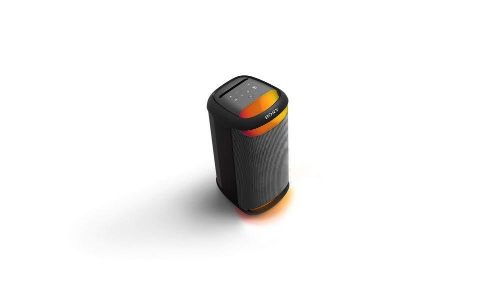 Altavoz cilíndrico negro y gris con detalles en naranja y blanco, sobre fondo blanco.