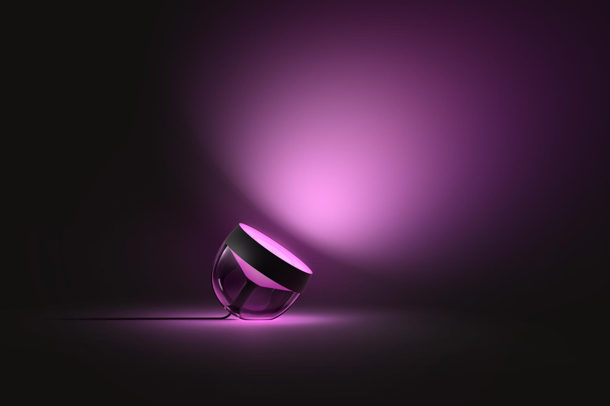Ein rosa Licht liegt auf einer schwarzen Oberfläche. Das Licht zeigt nach oben.