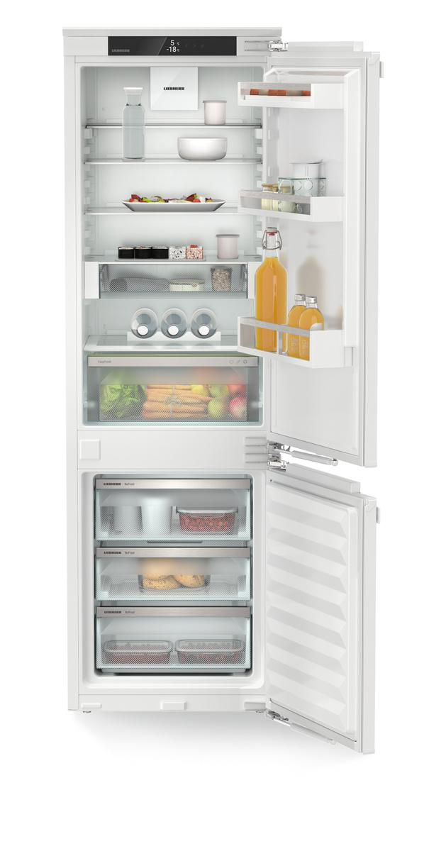 Weißer offener Kühlschrank mit Regalen und Inhalt, weißer Hintergrund.
