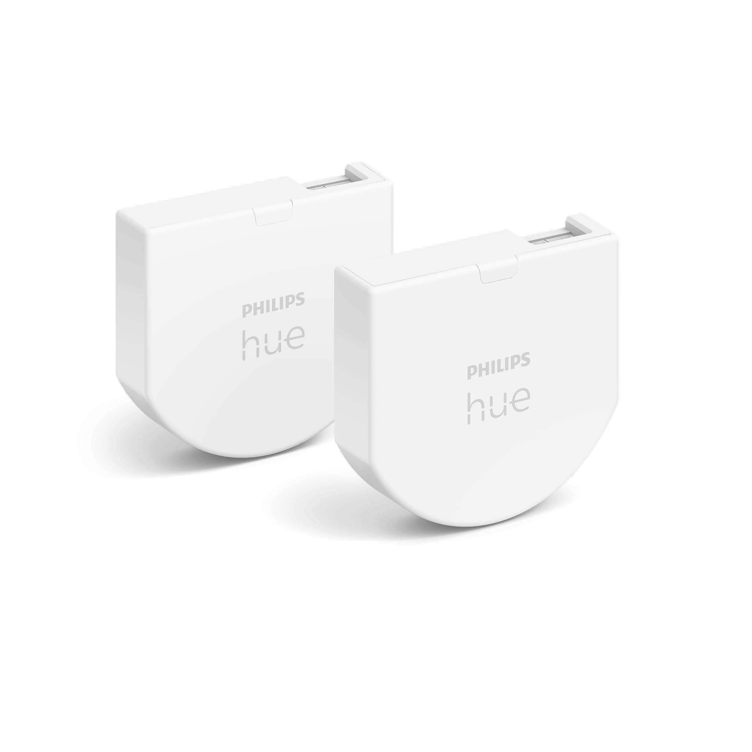 Zwei weiße Philips Hue Smart-Lichtsteuerungsgeräte mit abgerundeten Kanten auf weißer Oberfläche.
