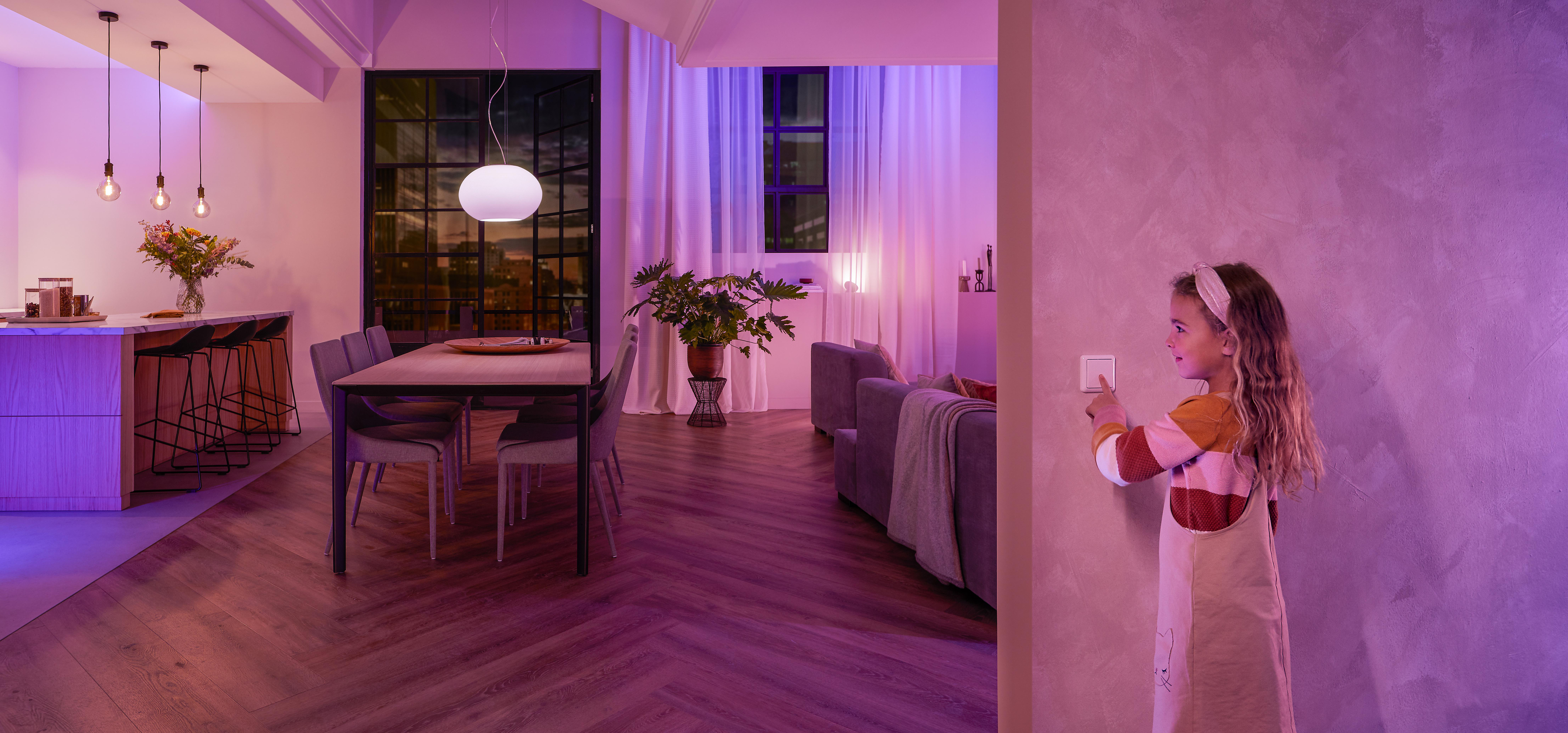 Ein Mädchen interagiert mit einem intelligenten Lichtschalter in einem modernen Zuhause.