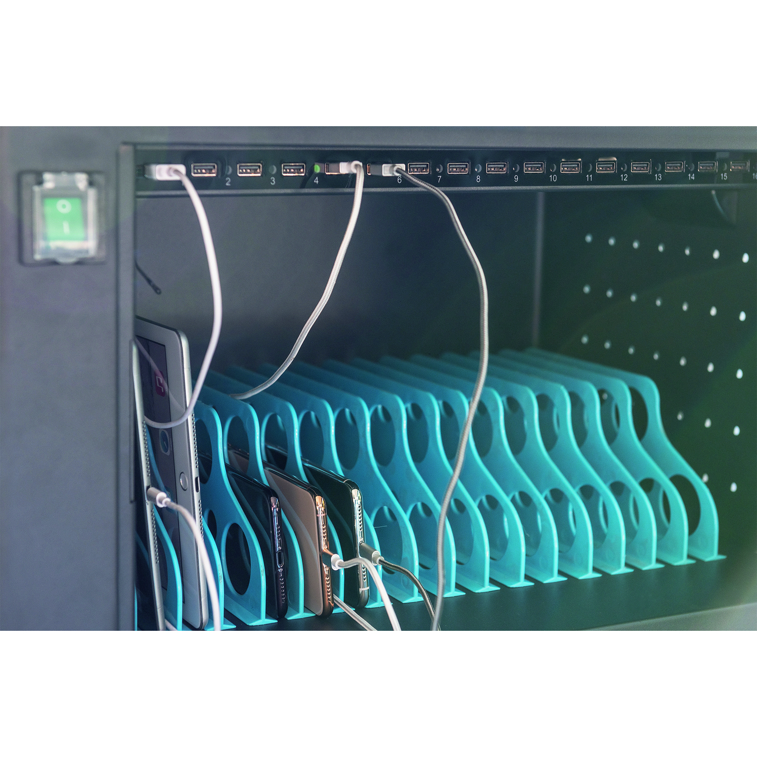 A charging station with phones and tablets plugged in.
