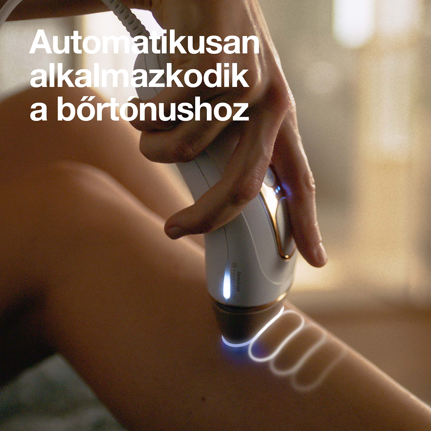Egy kéz szőrtelenítő eszközt használ egy lábon. Fényesen világít.
