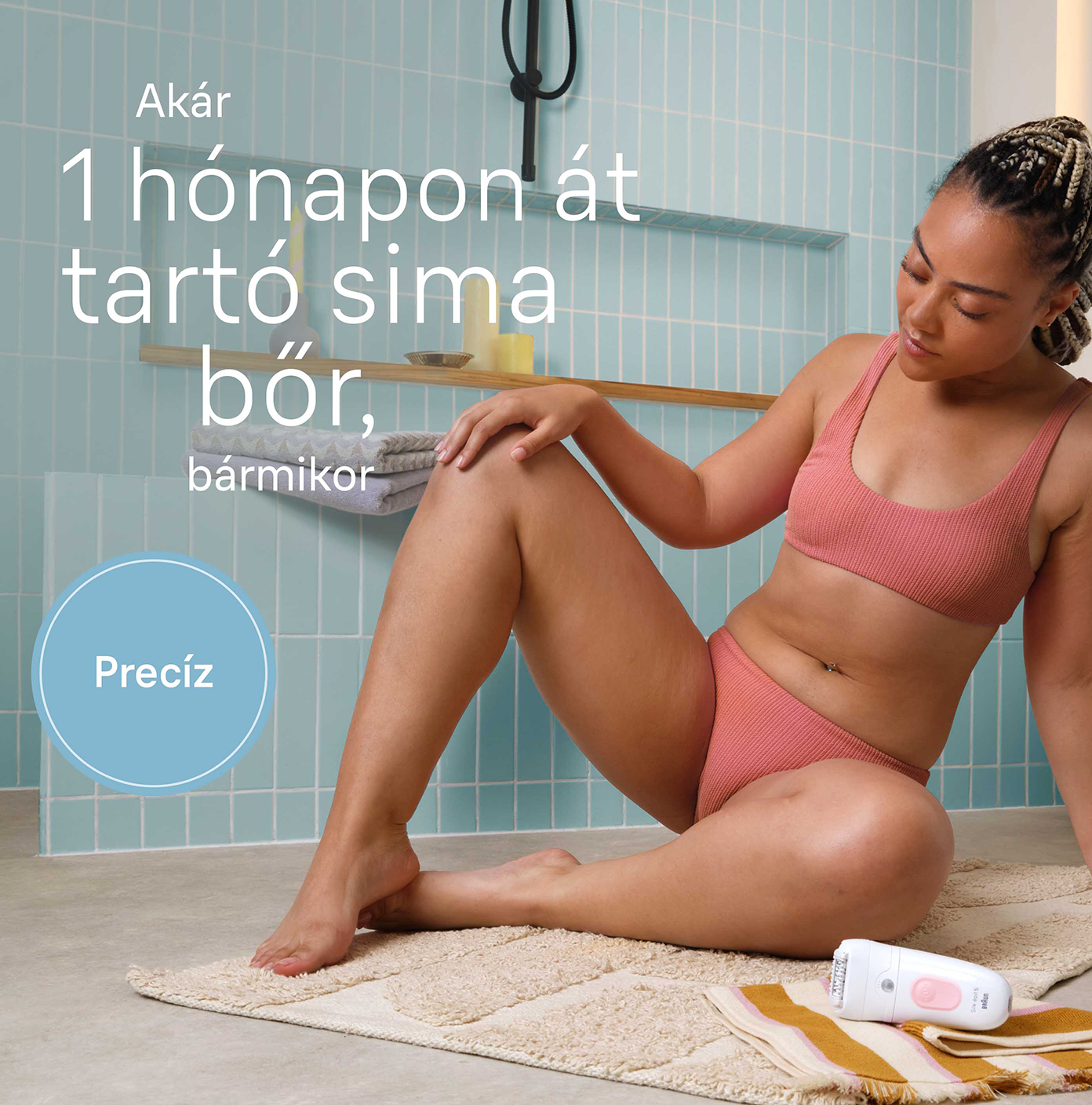 Nő a fürdőszobában epilátort használ. Egy szőnyegen ül, a kezében a készülékkel.