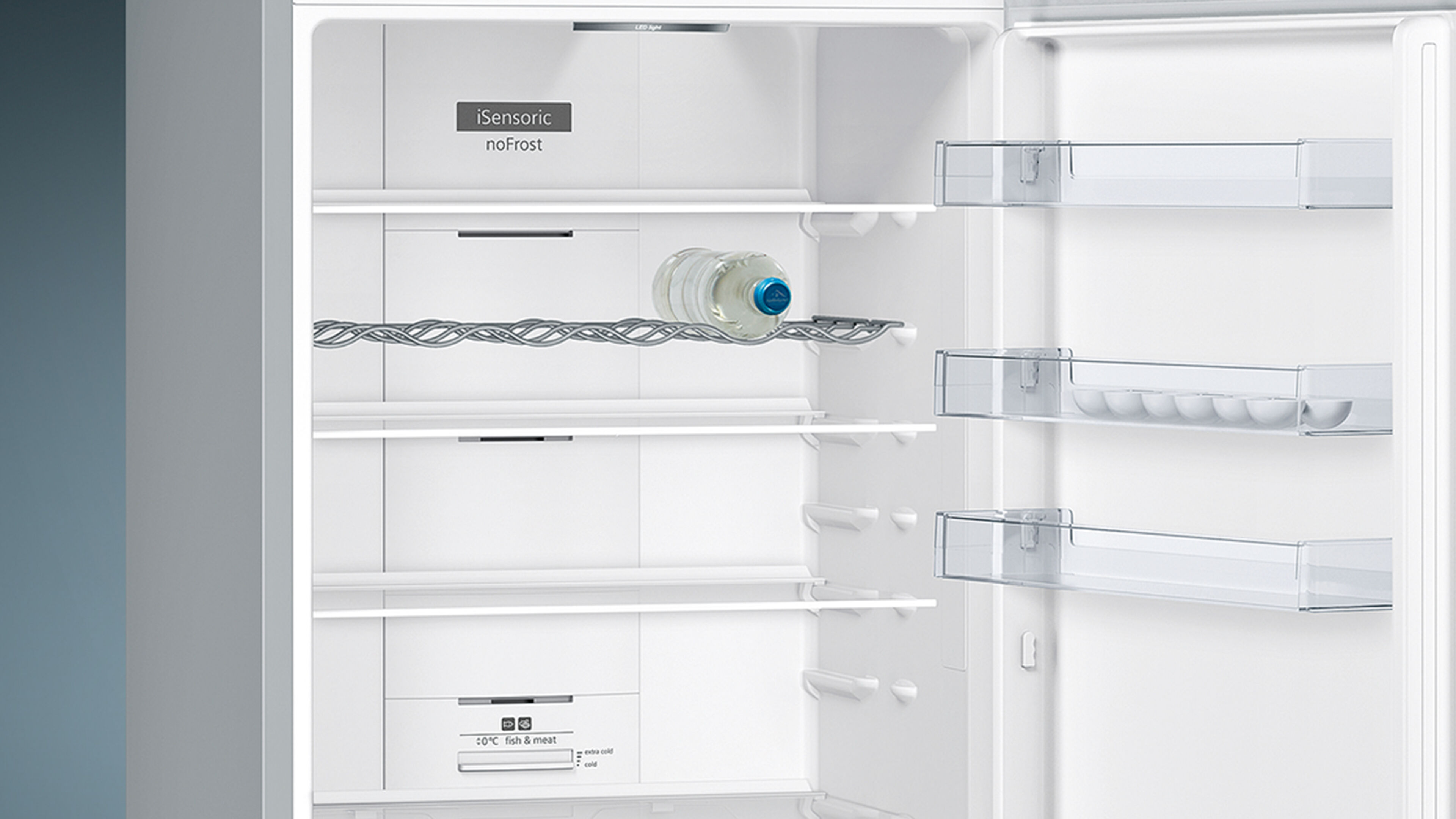 Interior del refrigerador Siemens. Estantes con botella de agua y estantes transparentes.