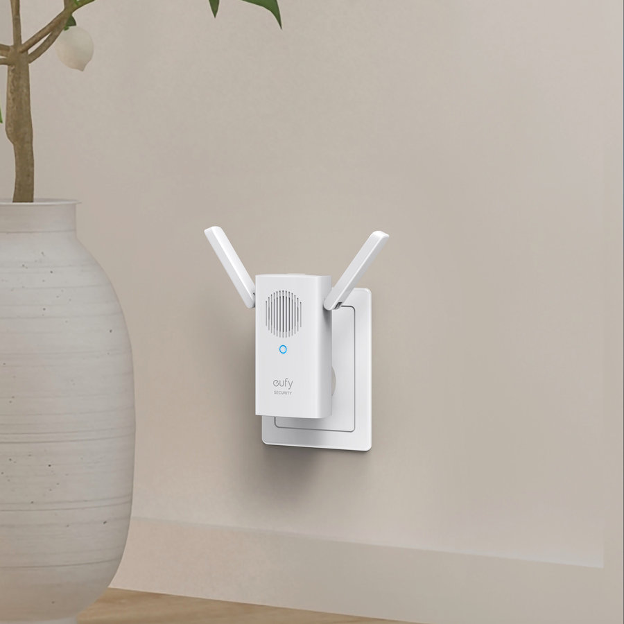 Biały wzmacniacz Wi-Fi w gniazdku ściennym. Beżowa ściana, biały wazon w tle.