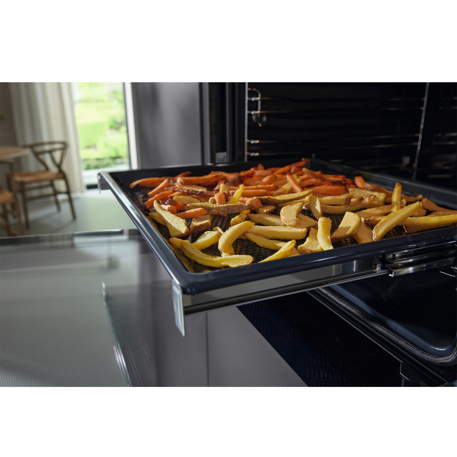 Un cassetto del forno con patatine fritte. Il forno è aperto, rivelando patatine fritte dorate e marroni.