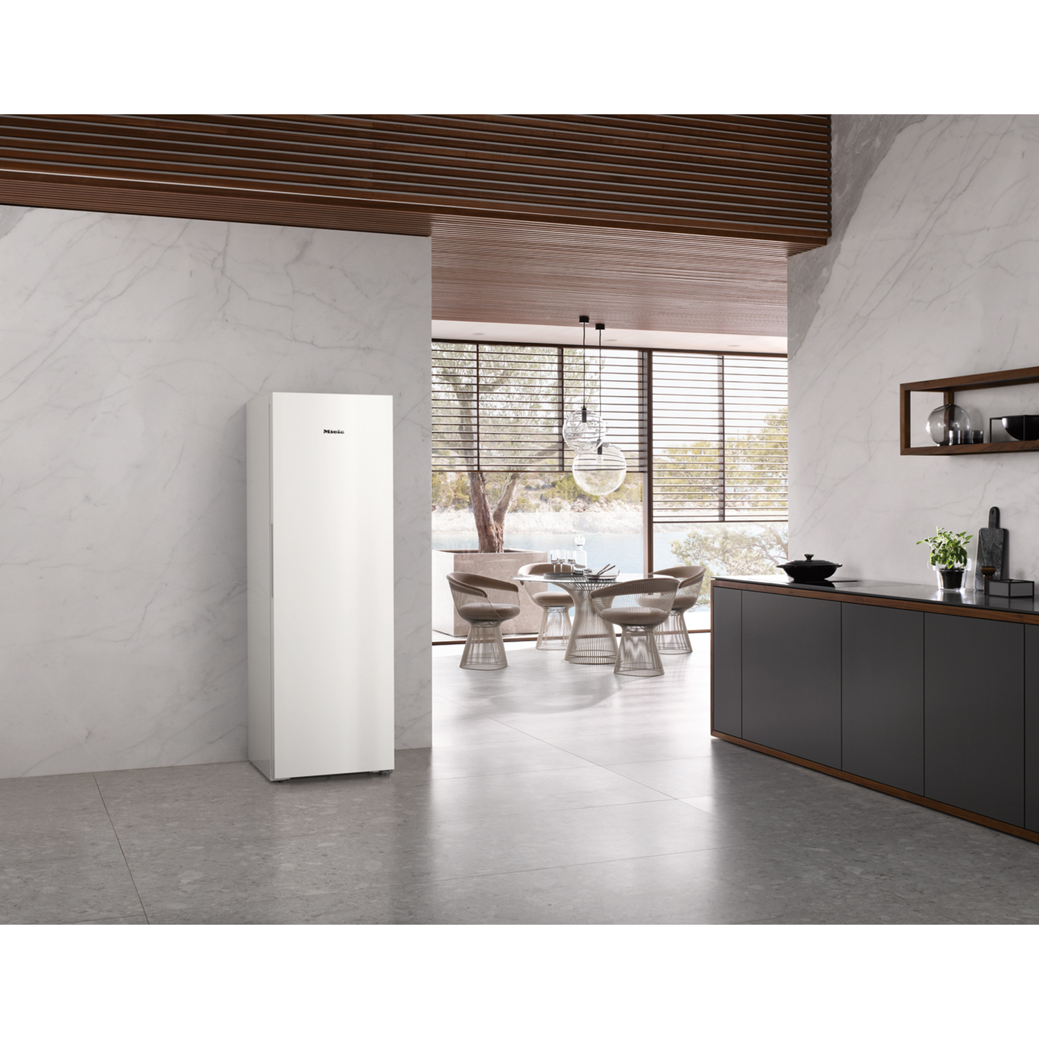 Interni cucina moderna con frigorifero bianco. Sfondo: tavolo, sedie, finestra.
