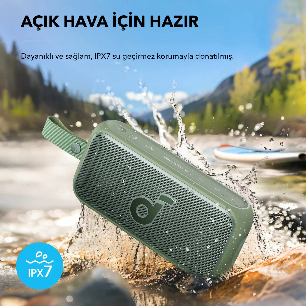Suda yeşil hoparlör, su sıçramaları ve dağ manzarası.