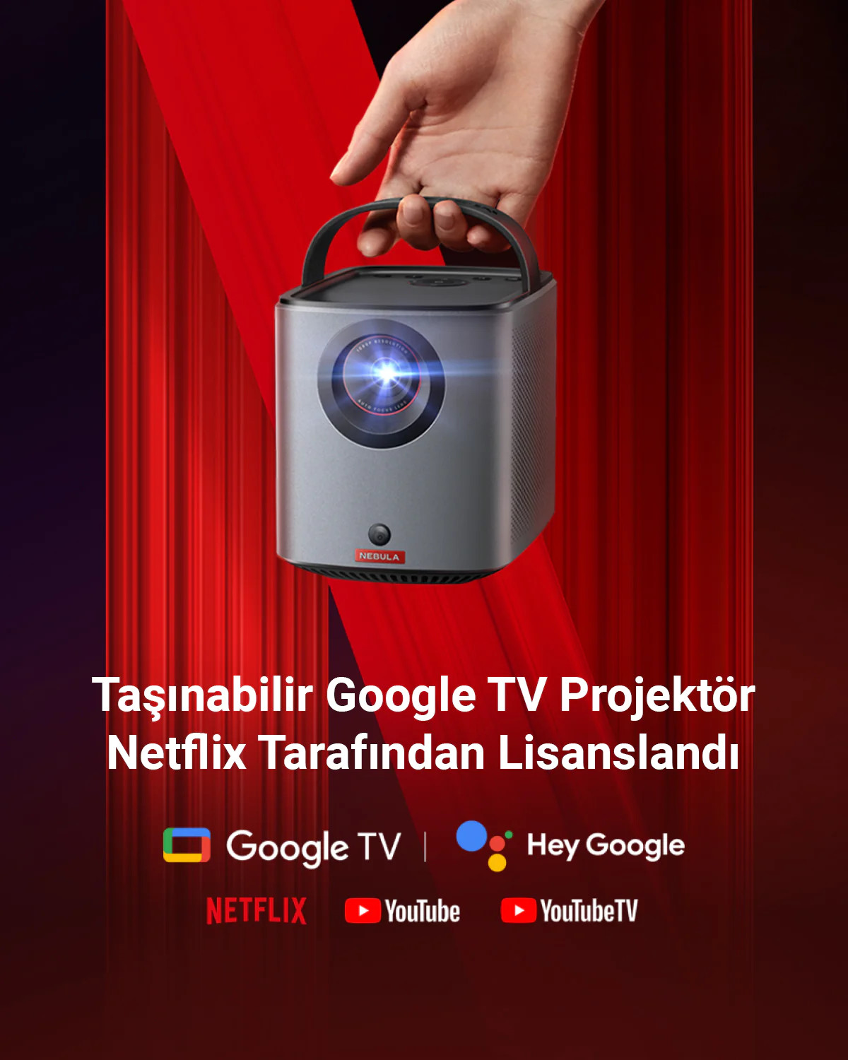 Bir el, üzerinde 'NEBULA' yazan gri bir projektörü tutuyor. Kırmızı perde arka planı.