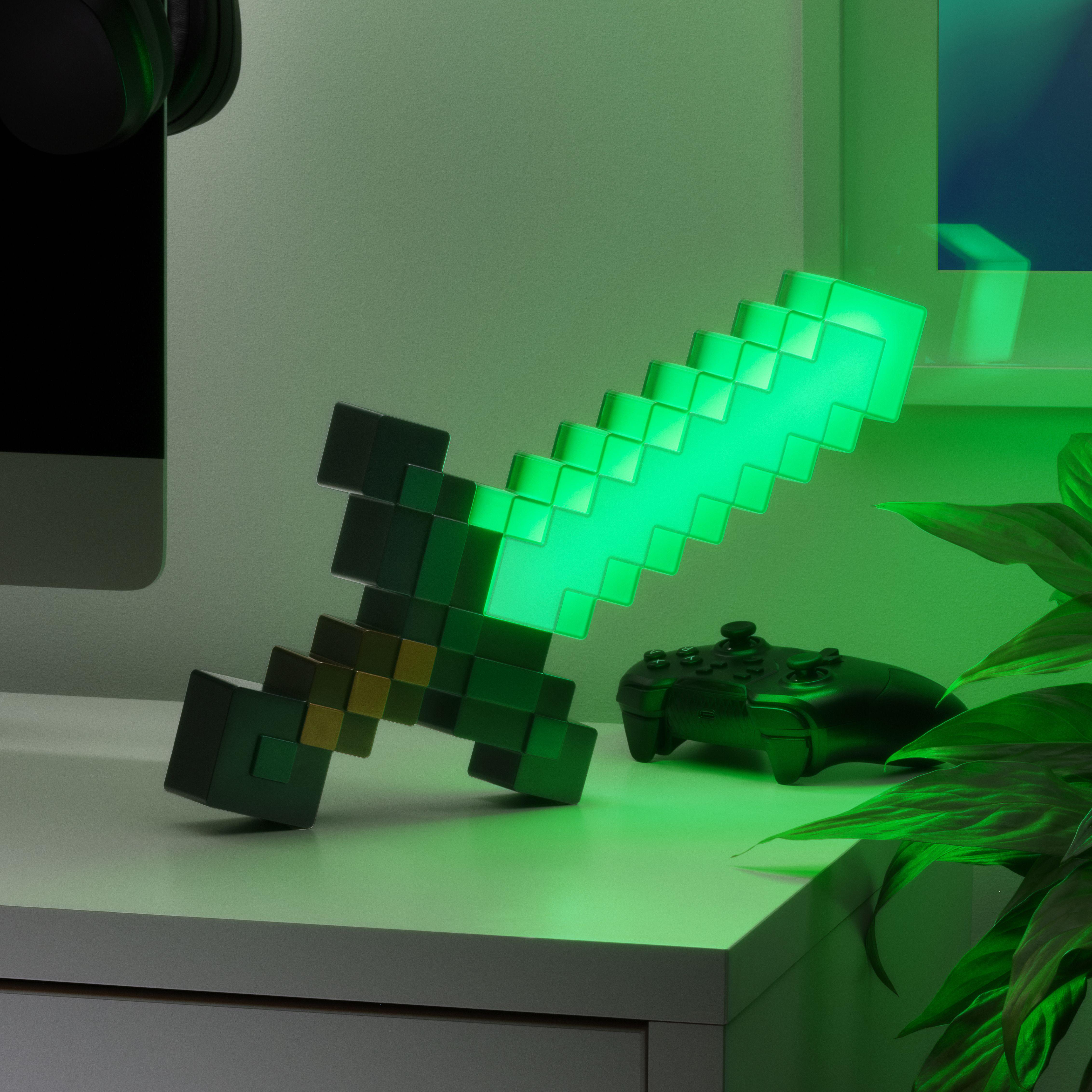 Grüne Minecraft-Schwertlampe auf einem Schreibtisch. Ein Controller und eine Pflanze sind ebenfalls auf dem Schreibtisch. Grünes Licht ist an.
