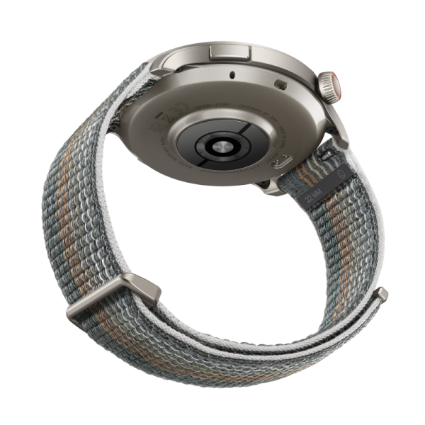 Spód smartwatcha z szarym i pomarańczowym paskiem z tkaniny, pokazujący tył zegarka.