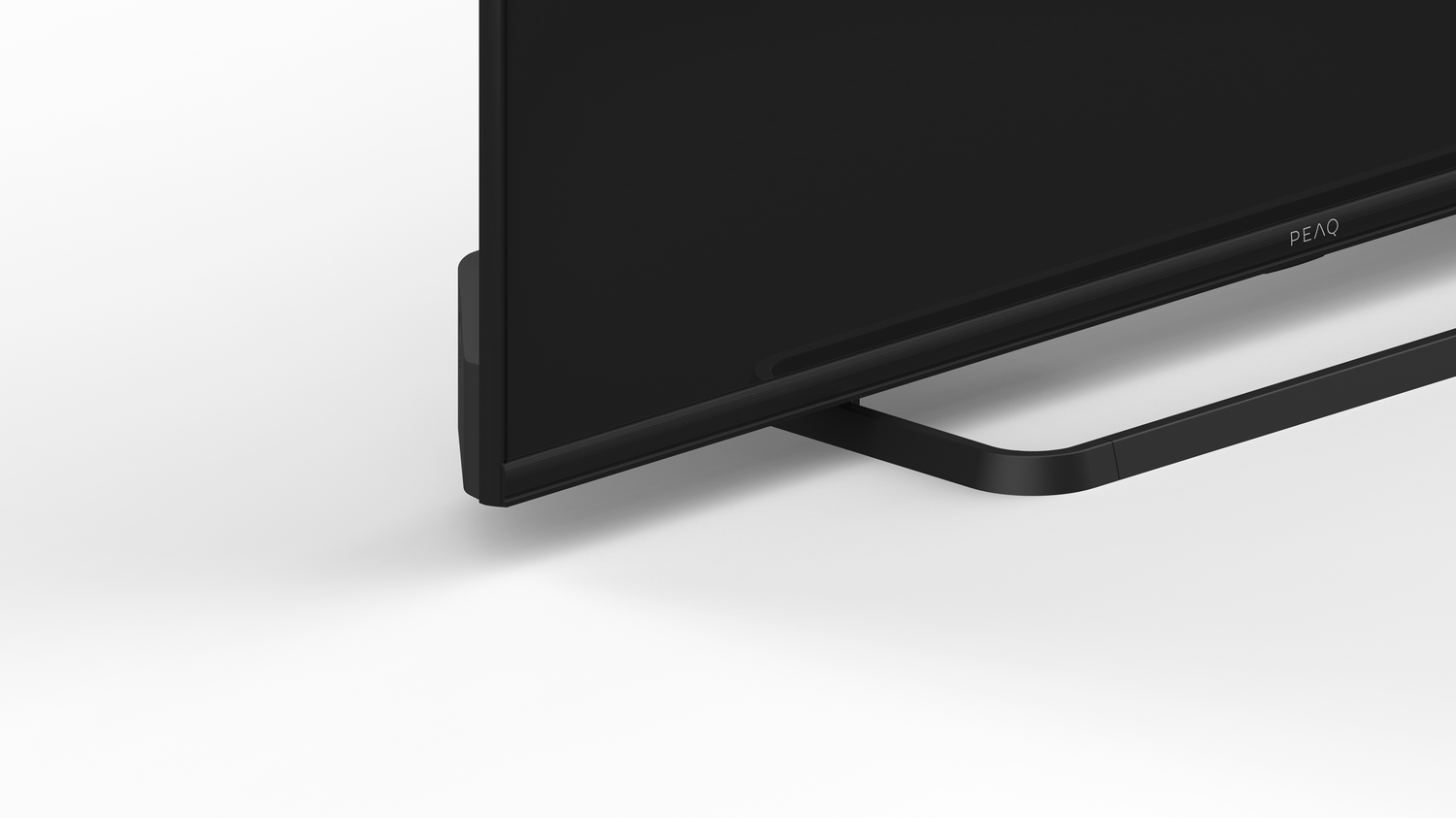 Pantalla de TV negra con soporte negro. El televisor está sobre una superficie blanca.