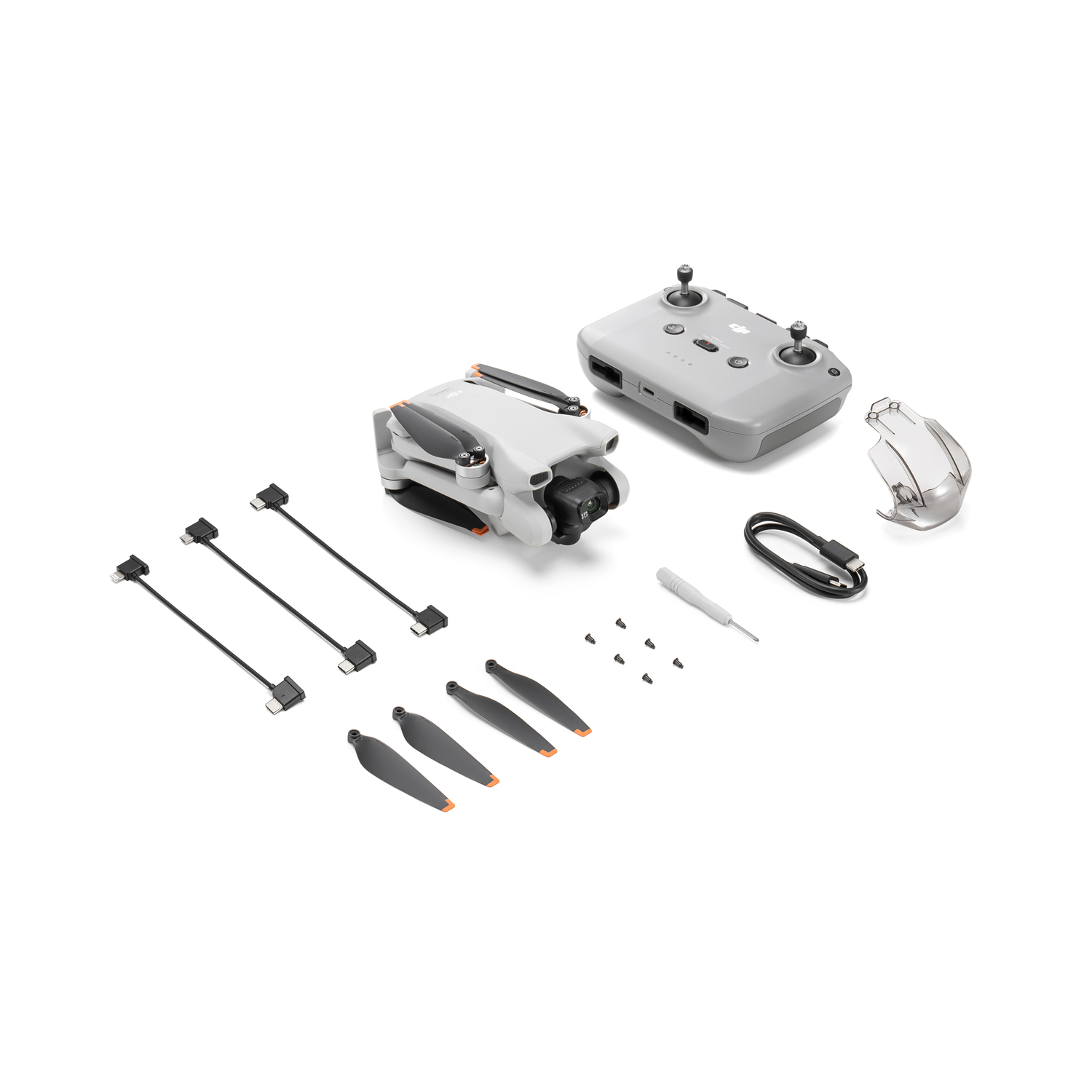 Drone and accessories laid out. Includes remote, blades, cables, and a screwdriver.