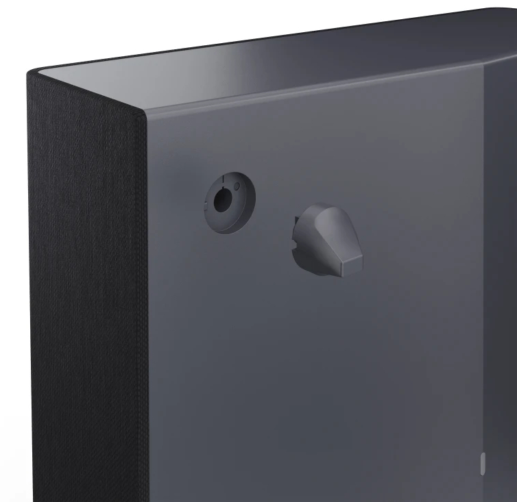 Bok ciemnoszarego urządzenia z przyciskiem i zagłębionym otworem na ciemnoszarym tle.