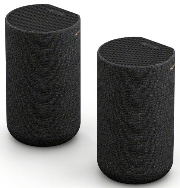 Dwa czarne głośniki cylindryczne z przyciskiem zasilania na górze. Tekstura materiału.